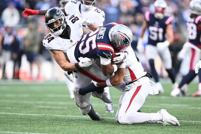 New England Patriots cornerback Marcus Jones is stopped on a return attempt by Atlanta Falcons tight end Feleipe Franks.