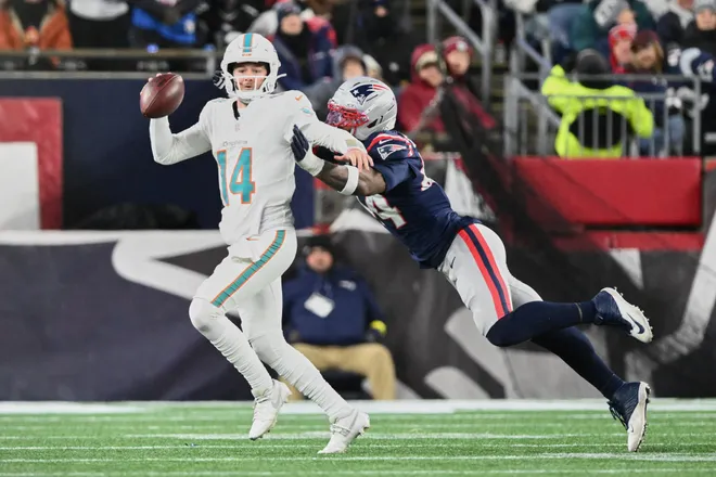 Miami Dolphins quarterback Quinn Ewers scrambles against New England Patriots linebacker K'Lavon Chaisson during the fourth quarter at Gillette Stadium.