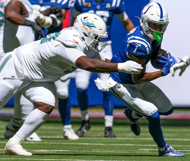 Miami Dolphins defensive tackle Kenneth Grant (90) attempts to take down Indianapolis Colts wide receiver Josh Downs (1) during the first half of a game Sunday, Sept. 7, 2025, at Lucas Oil Stadium in Indianapolis.