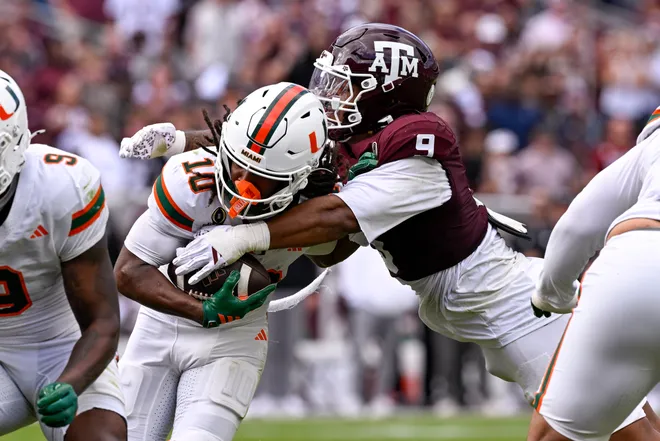 Dec 20, 2025; College Station, TX, USA; Texas A&M Aggies defensive end Cashius Howell (9) tackles Miami Hurricanes wide receiver Malachi Toney (10) during the game between the Aggies and the Hurricanes at Kyle Field. Mandatory Credit: Jerome Miron-Imagn Images