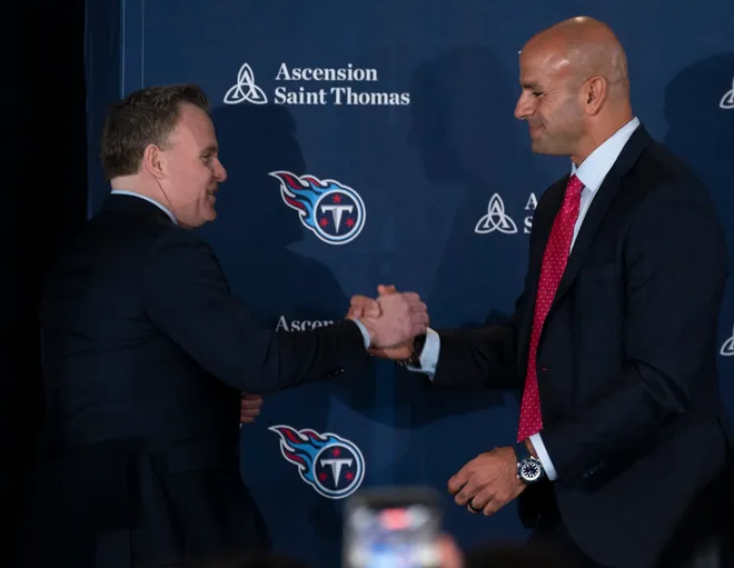 Tennessee Titans general manager Mike Borgonzi and Robert Saleh shake hands.