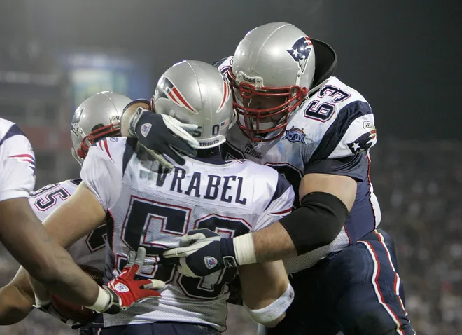 Guard Joe Andruzzi #63 of the New England Patriots celebrates with teammate linebacker Mike Vrabel #50 after Vrabel made a 2-yard touchdown reception.