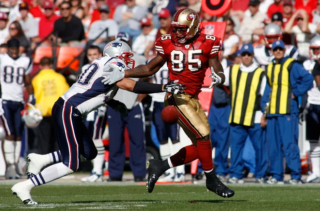 New England Patriots linebacker Mike Vrabel knocks the ball out of the hands of San Francisco 49ers tight end Vernon Davis.