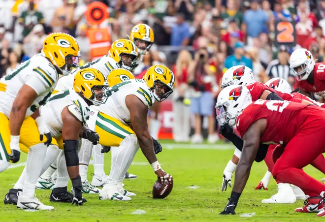Oct 19, 2025; Glendale, Arizona, USA; General view down the line of scrimmage as Green Bay Packers center Elgton Jenkins (74) prepares to snap the ball against the Arizona Cardinals at State Farm Stadium. Mandatory Credit: Mark J. Rebilas-Imagn Images