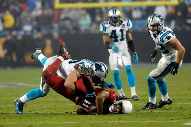 Jan 3, 2015; Charlotte, NC, USA; Arizona Cardinals wide receiver Larry Fitzgerald (11) catches a pass over Carolina Panthers middle linebacker Luke Kuechly (59) during the fourth quarter in the 2014 NFC Wild Card playoff football game at Bank of America Stadium. Mandatory Credit: Sam Sharpe-USA TODAY Sports