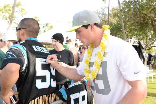 January 22, 2014; Ko'Olina, HI, USA; Team Sanders middle linebacker Luke Kuechly from Carolina Panthers (right) signs an autograph during the Pro Bowl draft at J.W. Marriott Ihilani Resort & Spa. Mandatory Credit: Kyle Terada-USA TODAY Sports