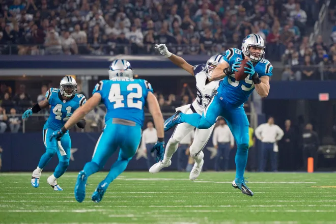 Nov 26, 2015; Arlington, TX, USA; Carolina Panthers middle linebacker Luke Kuechly (59) intercepts a pass thrown by Dallas Cowboys quarterback Tony Romo (not pictured) and scores a touchdown during the second quarter of an NFL game on Thanksgiving at AT&T Stadium. Mandatory Credit: Jerome Miron-USA TODAY Sports