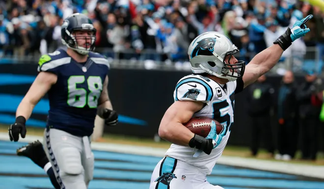 Jan 17, 2016; Charlotte, NC, USA; Carolina Panthers middle linebacker Luke Kuechly (59) scores a touchdown on an interception while guarded by Seattle Seahawks offensive guard Justin Britt (68) during the first quarter in a NFC Divisional round playoff game at Bank of America Stadium. Mandatory Credit: Jeremy Brevard-USA TODAY Sports