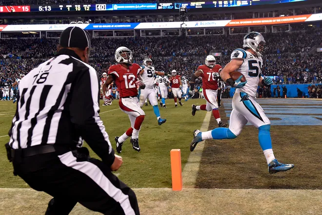 Jan 24, 2016; Charlotte, NC, USA; Carolina Panthers middle linebacker Luke Kuechly (59) returns an interception for touchdown during the fourth quarter against the Arizona Cardinals in the NFC Championship football game at Bank of America Stadium. Mandatory Credit: Bob Donnan-USA TODAY Sports