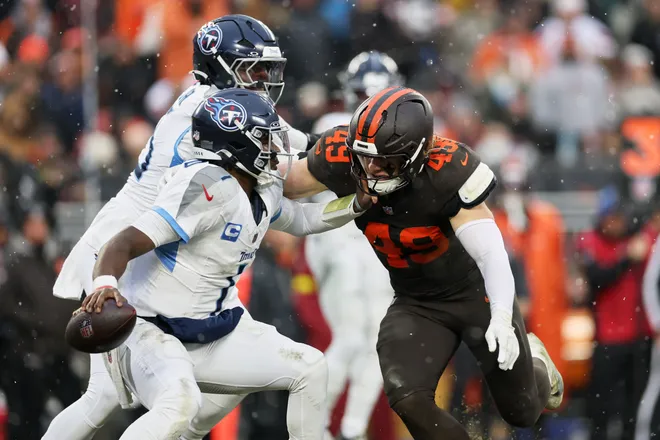 Dec 7, 2025; Cleveland, Ohio, USA; Cleveland Browns linebacker Carson Schwesinger (49) sacks Tennessee Titans quarterback Cam Ward (1) during the third quarter at Huntington Bank Field. Mandatory Credit: Scott Galvin-Imagn Images