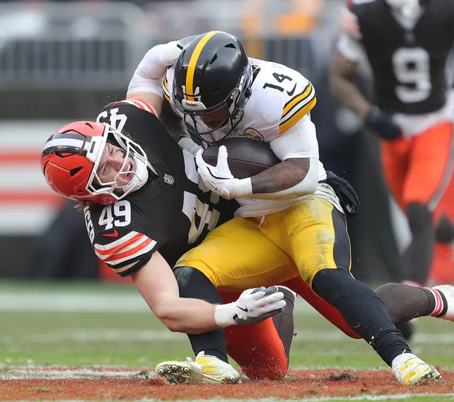 Cleveland Browns linebacker Carson Schwesinger (49) wraps up Pittsburgh Steelers running back Kenneth Gainwell (14) during the first half of an NFL football game at Huntington Bank Field, Dec. 28, 2025, in Cleveland, Ohio.