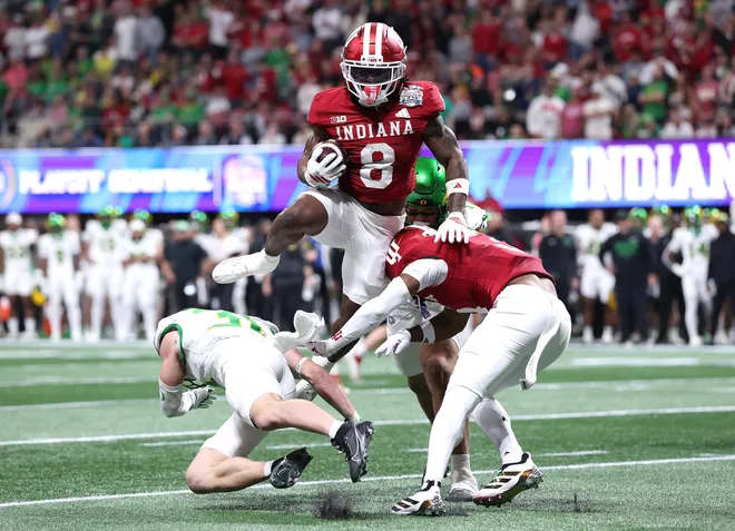 ATLANTA, GEORGIA - JANUARY 09: Kaelon Black #8 of the Indiana Hoosiers leaps over Dillon Thieneman #31 of the Oregon Ducks and Omar Cooper Jr. #3 of the Indiana Hoosiers during the second quarter of the 2025 College Football Playoff Semifinal at the Chick-fil-A Peach Bowl at Mercedes-Benz Stadium on January 09, 2026 in Atlanta, Georgia. (Photo by Kevin C. Cox/Getty Images)