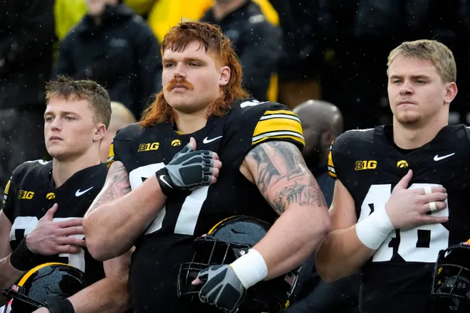 Iowa Hawkeyes offensive lineman Gennings Dunker (67), center, stands with teammates for the national anthem Nov. 8, 2025 before a Big Ten Football game against the Oregon Ducks at Kinnick Stadium in Iowa City, Iowa.