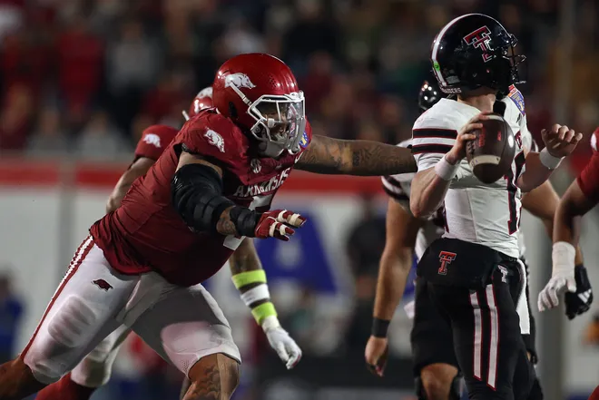 Dec 27, 2024; Memphis, TN, USA; Arkansas Razorbacks defensive linemen Cameron Ball (5) hits Texas Tech Red Raiders quarterback Will Hammond (15) as he throws during the forth quarter at Simmons Bank Liberty Stadium. Mandatory Credit: Petre Thomas-Imagn Images