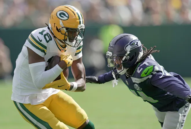 Green Bay Packers wide receiver Malik Heath (18) makes a catch before being tackles by Seattle Seahawks cornerback Shaquill Griffin (24) during the first quarter of their preseason game Saturday, August 23, 2025 at Lambeau Field in Green Bay, Wisconsin.