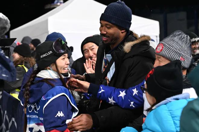 USA's Chloe Kim and Cleveland Browns defensive end Myles Garrett react.