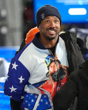 Cleveland Browns player Myles Garrett wears a jacket with a photo of Chloe Kim of the United States.
