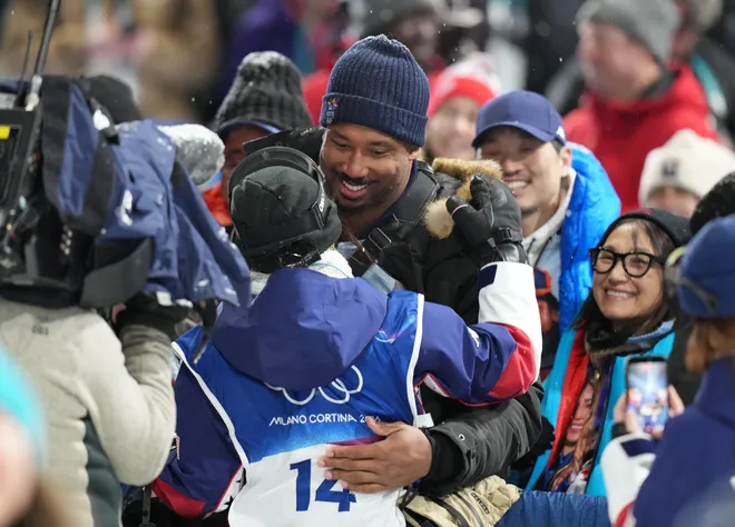 Chloe Kim of the United States gets a hug from Cleveland Browns player Myles Garrett after the first run in the women's halfpipe final.