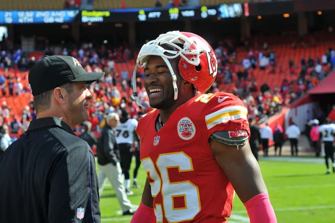 Baltimore Ravens head coach John Harbaugh talks with Kansas City Chiefs cornerback Stanford Routt.