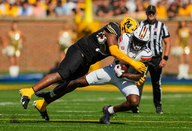 Oct 19, 2024; Columbia, Missouri, USA; Auburn Tigers tight end Rivaldo Fairweather (13) is tackled by Missouri Tigers defensive tackle Chris McClellan (7) during the first half at Faurot Field at Memorial Stadium. Mandatory Credit: Jay Biggerstaff-Imagn Images