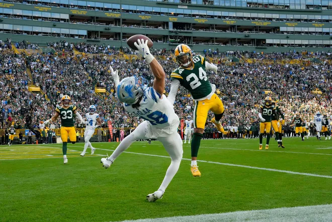 Sep 7, 2025; Green Bay, Wisconsin, USA; Detroit Lions wide receiver Isaac TeSlaa (18) makes a catch for a touchdown against Green Bay Packers cornerback Carrington Valentine (24) during the fourth quarter at Lambeau Field. The play was originally ruled an incomplete pass but the call was overturned. Mandatory Credit: Jeff Hanisch-Imagn Images