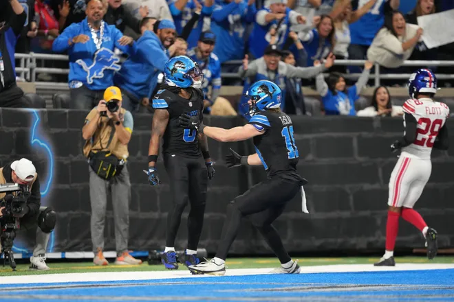 DETROIT, MICHIGAN - NOVEMBER 23: Jahmyr Gibbs #0 celebrates a touchdown during overtime with Isaac TeSlaa #18 of the Detroit Lions against the New York Giants at Ford Field on November 23, 2025 in Detroit, Michigan. (Photo by Nic Antaya/Getty Images)
