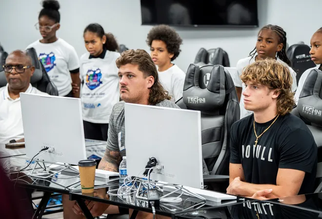 Detroit Lions rookie offensive lineman Tate Ratledge, center, and rookie wide receiver Isaac TeSlaa, right, listen to a speaker in a classroom with other Lions rookies as they take part in drone education with students from the Redford Service Learning Academy in Redford Township on Monday, June 9, 2025. The field trip was part of their introduction to the Detroit area to interact and fly ultra light drones with students in the program.