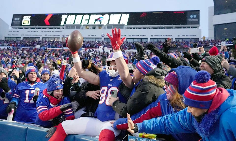 Bills tight end Dawson Knox leaps into the stands to celebrate with fans after scoring the opening touchdown of the game in first quarter against the Jets during the first half of their last regular season game at Highmark Stadium in Orchard Park Sunday, Jan. 4, 2026. The Bills won 35-8.