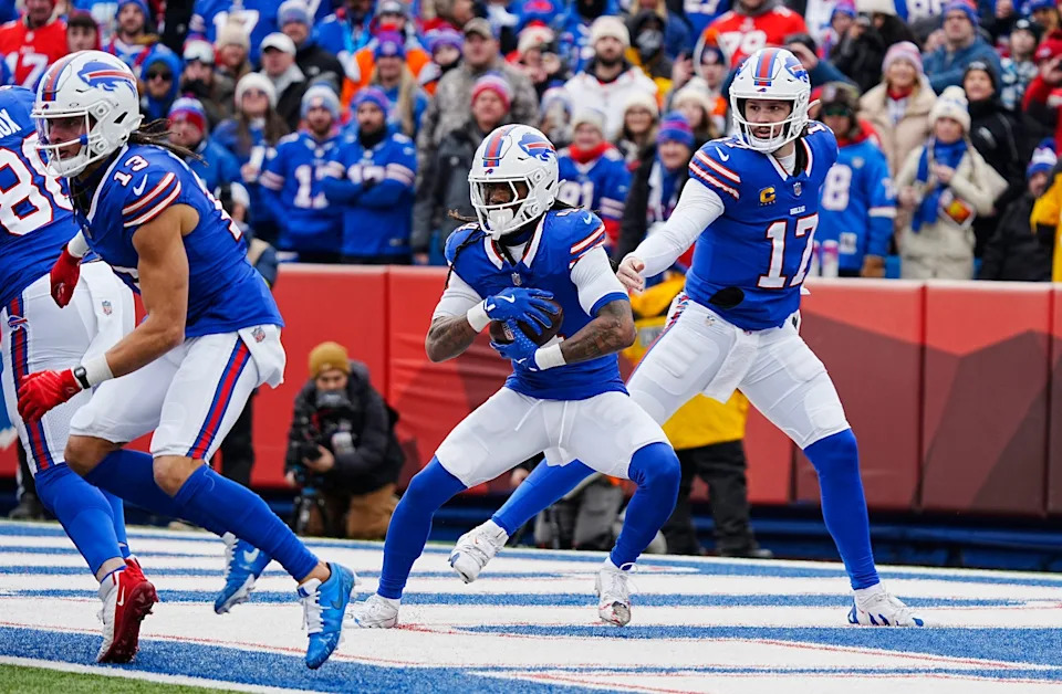 Buffalo Bills quarterback Josh Allen hands the ball off to Buffalo Bills running back James Cook during the first half of the Buffalo Bills wild card game against the Denver Broncos at Highmark Stadium in Orchard Park on Jan. 12, 2025. The punt return and a team foul put the team on the goal line. Cook ran it out for a first down.