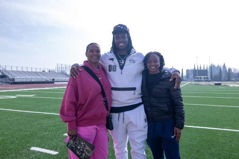 Jeremiah Pharms stands on a football field with family members at Delta College