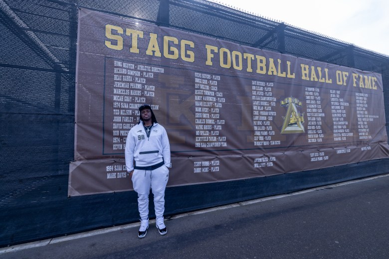 Jeremiah Pharms stands in front of the Stagg High School Football Hall of Fame banner.