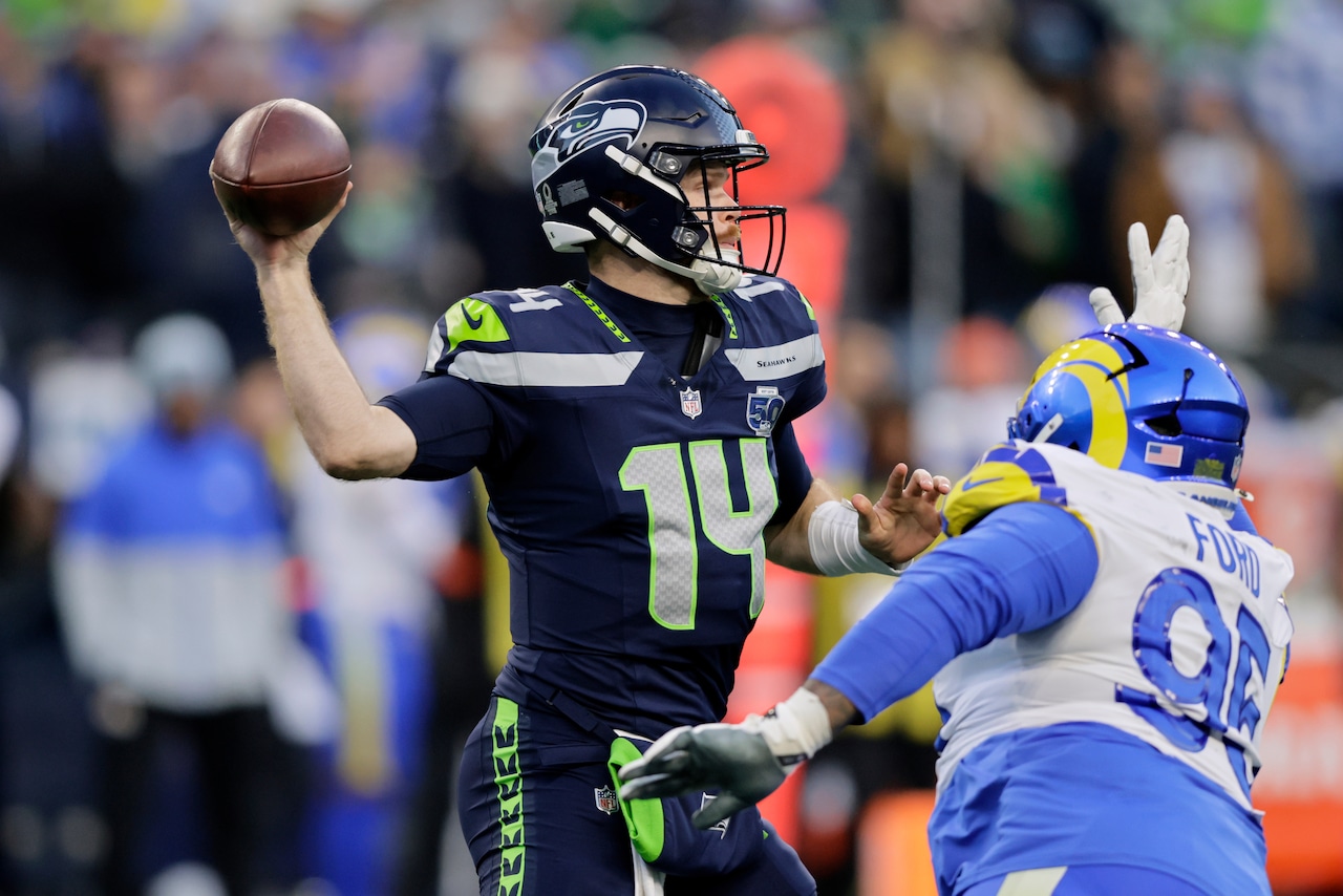 Seattle Seahawks quarterback Sam Darnold gets the ball out of his hand before the Los Angeles Rams defender can sack him.