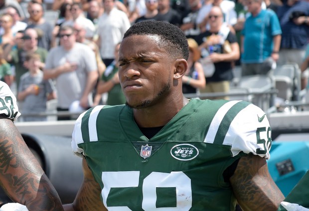 New York Jets inside linebacker Darron Lee lock arms while standing for the singing of the national anthem before an NFL football game against the Jacksonville Jaguars Sunday, Sept. 30, 2018, in Jacksonville, Fla. (AP Photo/Phelan M. Ebenhack)