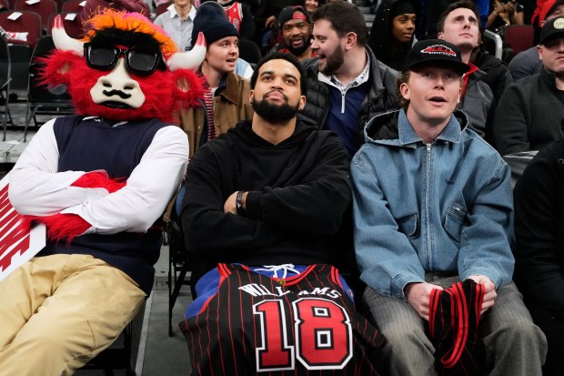 Chicago Bulls mascot Benny the Bull, left, Chicago Bears quarterback Caleb Williams, center, and Chicago Cubs center fielder Pete Crow-Armstrong watch during the second half of an NBA basketball game between the Los Angeles Clippers and the Chicago Bulls in Chicago, Tuesday, Jan. 20, 2026. (AP Photo/Nam Y. Huh)