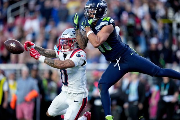 New England Patriots cornerback Christian Gonzalez (0) breaks up a pass intended for Seattle Seahawks wide receiver Jaxon Smith-Njigba, right, during the first half of the NFL Super Bowl LX, Sunday, Feb. 8, 2026, in Santa Clara, Calif. (AP Photo/Sue Ogrocki)