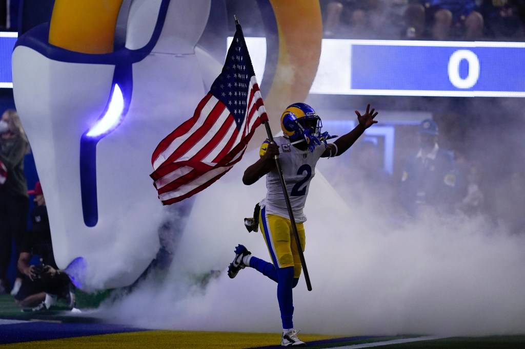 Robert Woods running onto the field carrying an American flag.