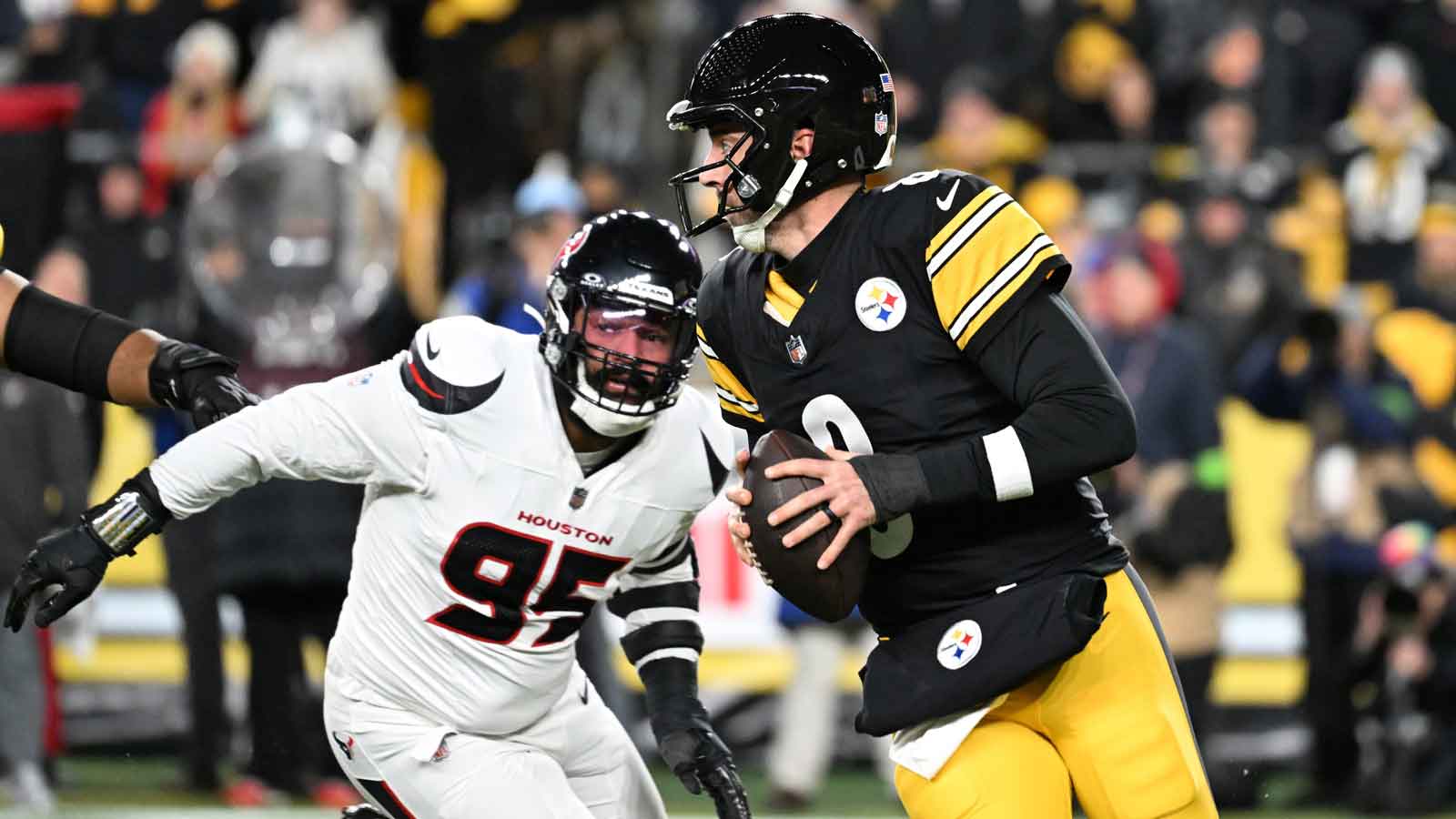 Pittsburgh Steelers quarterback Aaron Rodgers (8) scrambles from Houston Texans defensive end Derek Barnett (95) during the first half of an AFC Wild Card Round game at Acrisure Stadium.