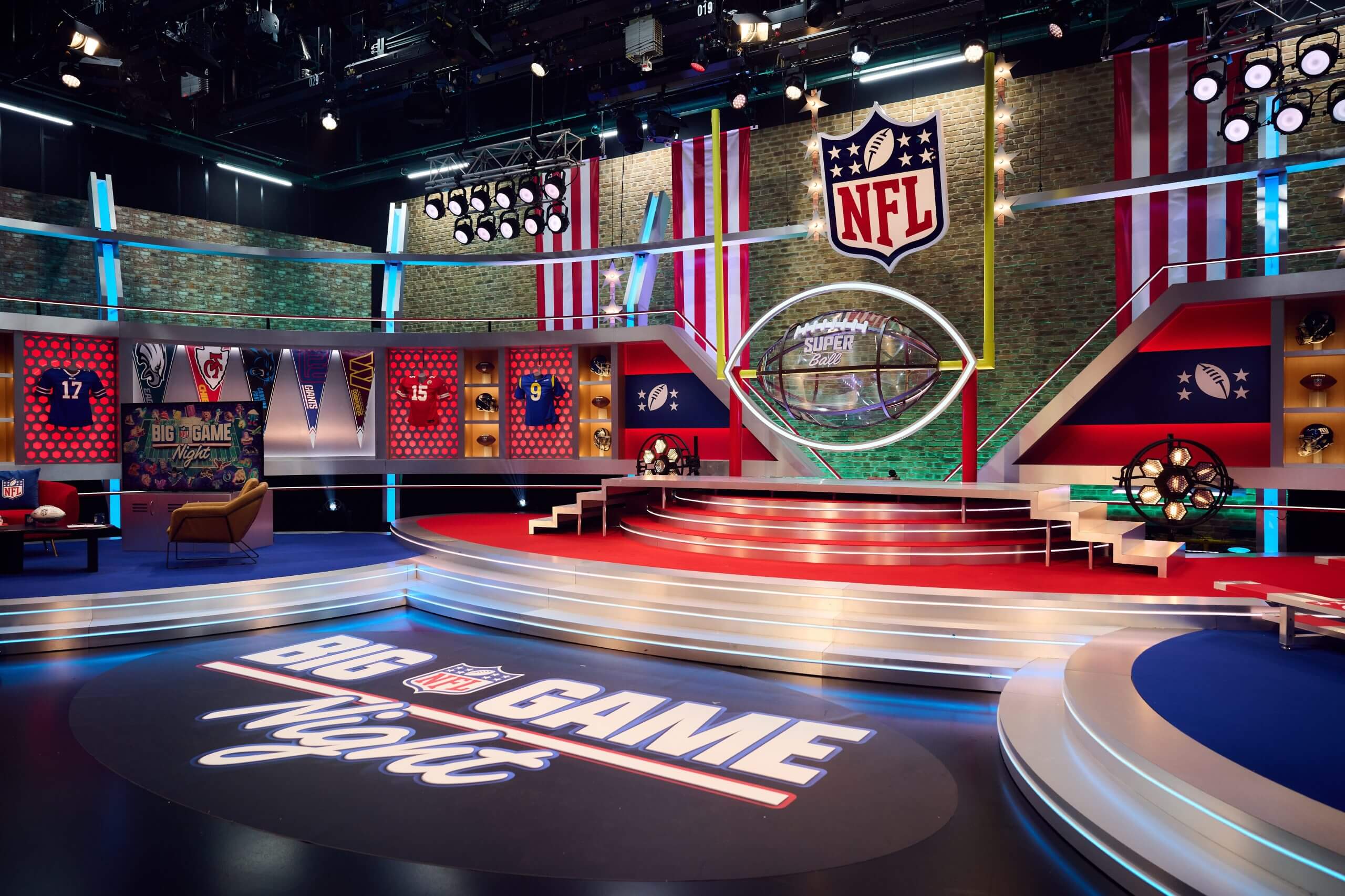 A picture of Channel 5's studio for Big Game Night, featuring steps, seats, the NFL shield and shirts hung in pseudo lockers