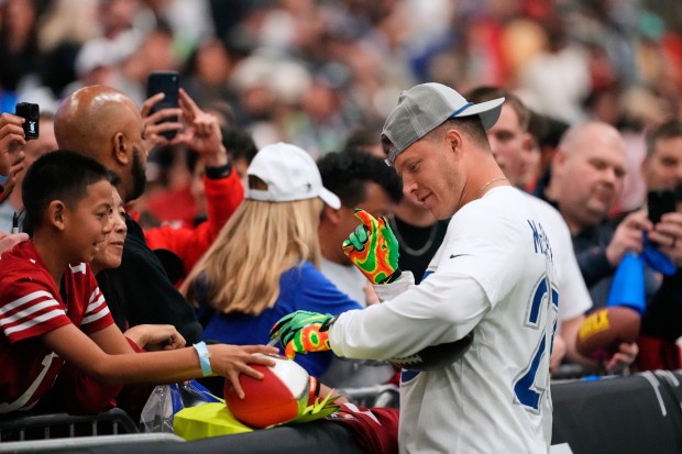 NFC running back Christian McCaffrey (23), of the San Francisco 49ers, signs an autograph for a fan before the NFL Pro Bowl football game against the AFC, Tuesday, Feb. 3, 2026, in San Francisco. (AP Photo/Jeff Chiu)