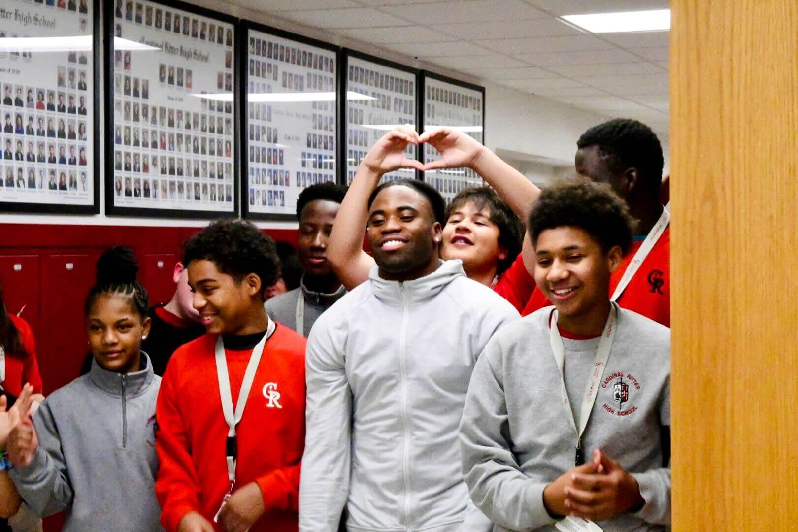 Kenny Moore II, with a white zip-front top, among students at Cardinal Ritter High.