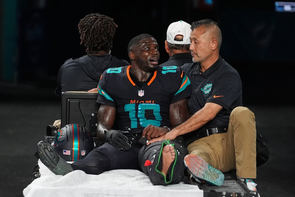 Miami Dolphins wide receiver Tyreek Hill (10) talks with a staff member as he is carted off...