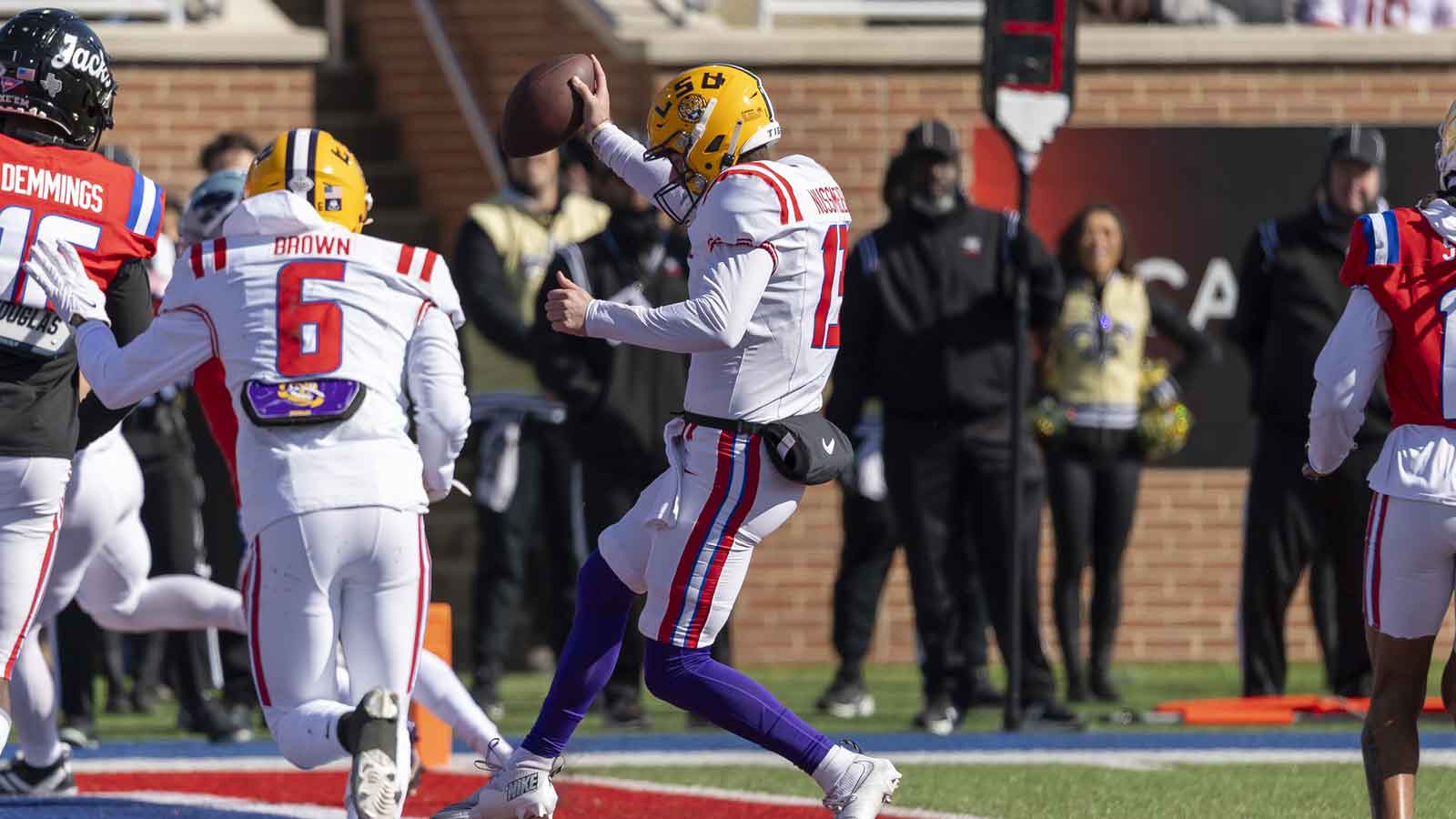 American Team defensive tackle Rayshaun Benny (26) of Michigan battles American Team offensive lineman Jake Slaughter (66) of Florida to get to American Team quarterback Garrett Nussmeier (13) during American Senior Bowl practice at Hancock Whitney Stadium.