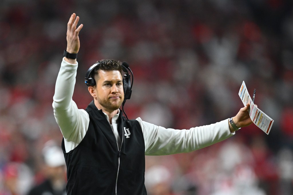 Indiana Hoosiers Quarterbacks Coach and Co-Offensive Coordinator Chandler Whitmer motions during the Big Ten Conference Championship game between the Indiana Hoosiers and the Ohio State Buckeyes on December 6, 2025, at Lucas Oil Stadium in Indianapolis, Indiana.