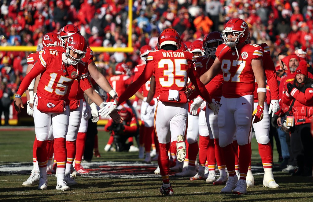 Jaylen Watson #35 of the Kansas City Chiefs is greeted by Patrick Mahomes #15 and Travis Kelce #87 during player introductions prior to the game against the Los Angeles Chargers at Arrowhead Stadium on December 14, 2025 in Kansas City, Missouri. 
