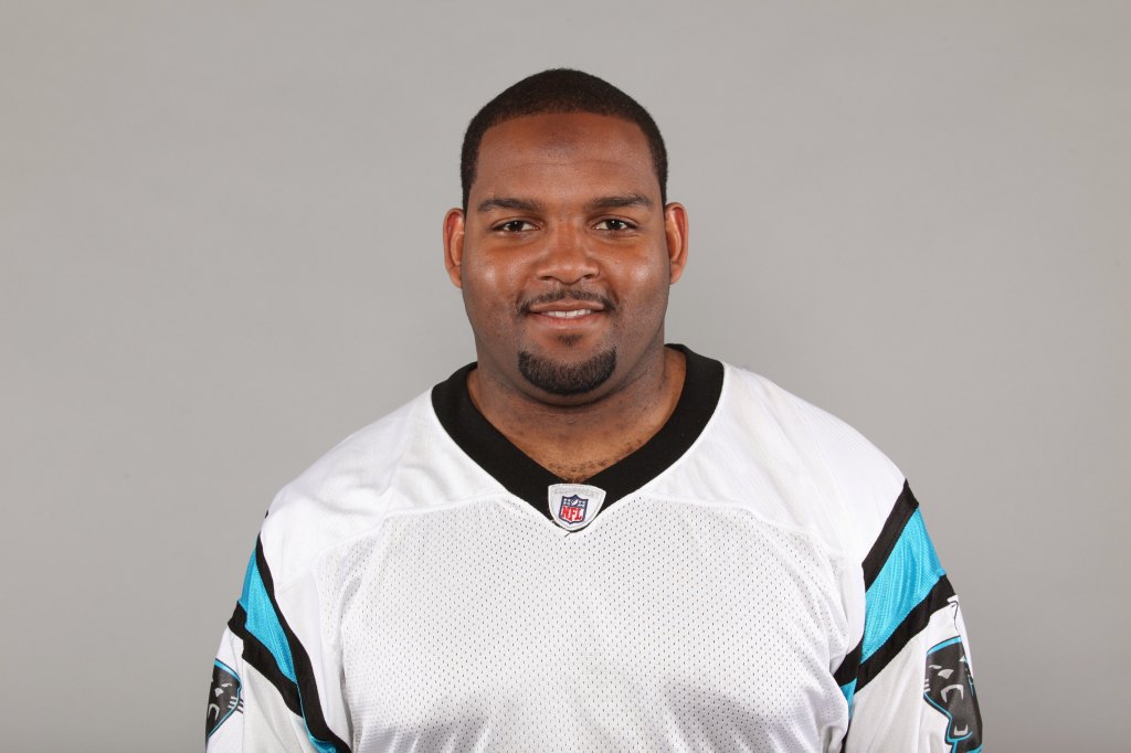 A man in a white Carolina Panthers jersey.
