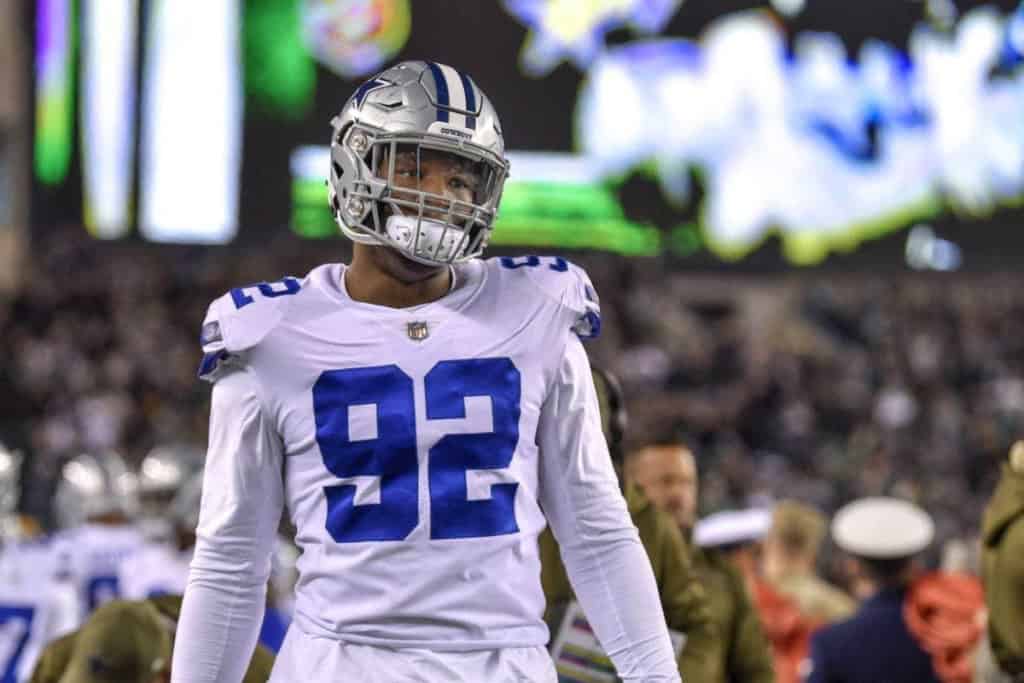 Dorance Armstrong lines up on defense during a night game, representing past free agents the Cowboys spent money on in recent seasons.