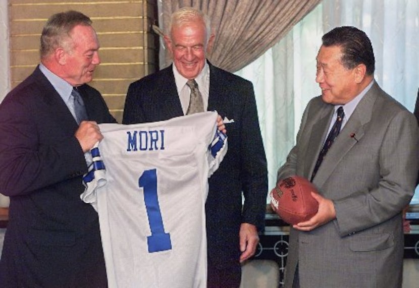 Owner and General Manager of Dallas Cowboys' Jerry Jones, left, presents a team's uniform to...
