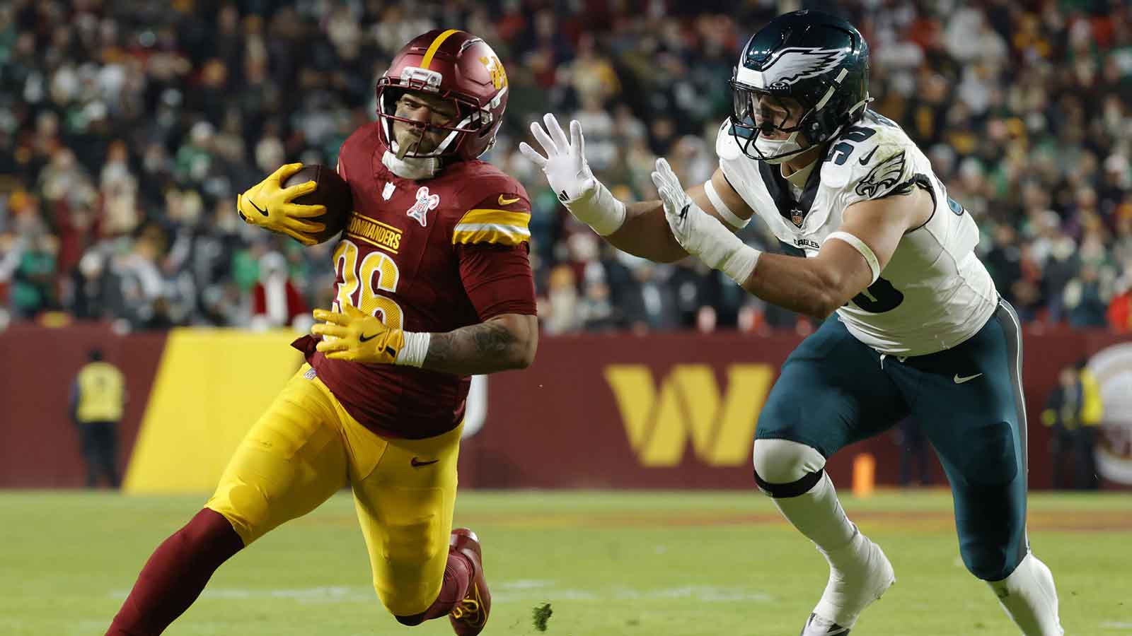 Washington Commanders running back Chris Rodriguez Jr. (36) runs against Philadelphia Eagles linebacker Jaelan Phillips (50) during the first half at Northwest Stadium. 