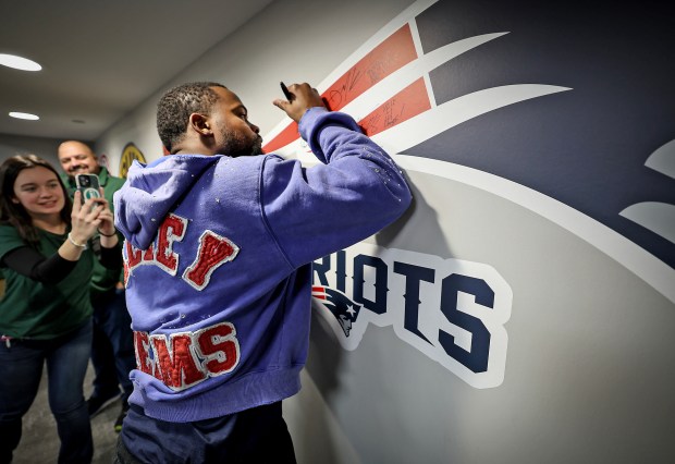 New England Patriots wide receiver Kayshon Boutte signs a wall at Dick's House of Sport on Boylston Street in Boston, Friday. Boutte signed autographs for fans inside the store. (Mark Stockwell/Boston Herald)