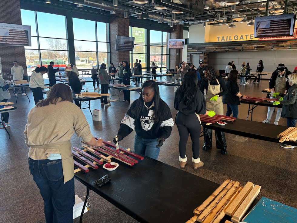 Representatives from all 32 NFL teams build wooden American flags for veterans at Lambeau Field